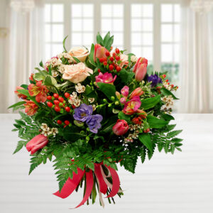 Bouquet "Sweet Dreams" con rose pesca, tulipani rosa, fresie viola e bacche rosse, legato con nastro rosso.