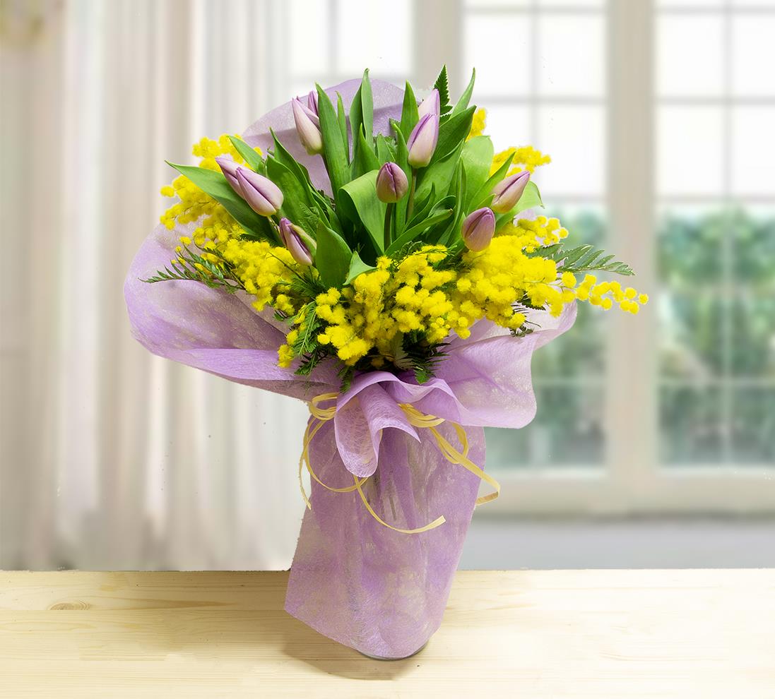 Bouquet Woman con 10 tulipani lilla e rami di mimosa gialla confezionato in carta velina viola con nastro giallo.